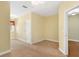 Spacious carpeted bedroom featuring a window and white door leading to an adjacent hardwood floor space at 37008 Shalimar Dr, Fruitland Park, FL 34731