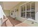 Welcoming front porch with brick flooring, shuttered windows, and a decorative wreath on the front door at 37008 Shalimar Dr, Fruitland Park, FL 34731