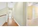 Hallway featuring beautiful hardwood floors leading to carpeted bedroom at 37008 Shalimar Dr, Fruitland Park, FL 34731