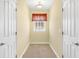 Narrow carpeted hallway featuring a window between two white paneled doors at 37008 Shalimar Dr, Fruitland Park, FL 34731