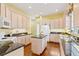 Spacious kitchen with white cabinetry, granite countertops and a center island at 37008 Shalimar Dr, Fruitland Park, FL 34731