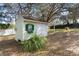 Cozy storage shed featuring a window box and dual doors, set amidst a serene backyard setting at 37008 Shalimar Dr, Fruitland Park, FL 34731