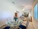 Open living area with glass table and wicker chairs, showing access to a bedroom and sunroom at 3716 Plantation Blvd, Leesburg, FL 34748