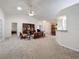 Bright living room features vaulted ceilings, ceiling fan, and neutral carpeting at 3716 Plantation Blvd, Leesburg, FL 34748