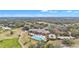 Stunning aerial view of the community clubhouse, pool, and golf course with mature trees and manicured lawns at 39335 Harbor Hills Blvd, Lady Lake, FL 32159