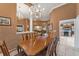 Spacious dining room with a large table and chandelier, views into the kitchen and living room at 39335 Harbor Hills Blvd, Lady Lake, FL 32159