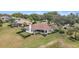 Aerial view showcases the backyard of a home, featuring serene lake views, lush greenery, and a golf course at 39335 Harbor Hills Blvd, Lady Lake, FL 32159