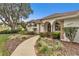 Charming home with stucco exterior, complemented by arched entryways and meticulous landscaping along the walkway at 39335 Harbor Hills Blvd, Lady Lake, FL 32159