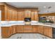 Kitchen with warm lighting, wood cabinetry, and a view to an exterior window providing natural light at 39335 Harbor Hills Blvd, Lady Lake, FL 32159