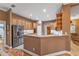 Kitchen showcasing stainless steel refrigerator and wooden cabinets with an adjacent eat-in bar at 39335 Harbor Hills Blvd, Lady Lake, FL 32159