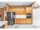 Kitchen featuring stainless steel appliances and warm wooden cabinetry with white countertops and backsplash at 39335 Harbor Hills Blvd, Lady Lake, FL 32159