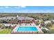 Aerial view showcases a sparkling pool and hot tub surrounded by lush landscaping and lounge chairs at 39335 Harbor Hills Blvd, Lady Lake, FL 32159