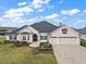 Beautiful two-story home with a three-car garage, landscaping, and paver driveway at 4038 Swaying Palm Ct, The Villages, FL 32163