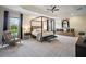 Spacious main bedroom with a four-poster bed and sitting area at 4038 Swaying Palm Ct, The Villages, FL 32163