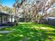 Large backyard with lush lawn and mature trees at 405 Mission Ln, Howey In The Hills, FL 34737