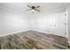 Simple bedroom with wood-look floors and ceiling fan at 405 Mission Ln, Howey In The Hills, FL 34737