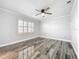 Bright bedroom with wood-look floors and plantation shutters at 405 Mission Ln, Howey In The Hills, FL 34737