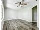 Bedroom featuring wood-look floors, ceiling fan, and large window at 405 Mission Ln, Howey In The Hills, FL 34737