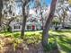 House exterior showcasing landscaping and mature oak trees framing the home at 405 Mission Ln, Howey In The Hills, FL 34737