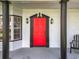 Red front door with black trim and sidelights at 405 Mission Ln, Howey In The Hills, FL 34737