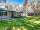 White house exterior showcasing a screened patio and yard at 405 Mission Ln, Howey In The Hills, FL 34737