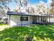 White house exterior with covered patio and green lawn at 405 Mission Ln, Howey In The Hills, FL 34737