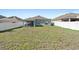 Large grassy backyard with a covered patio at 417 Pinecrest Loop, Davenport, FL 33837