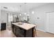 Kitchen island with double sink, dark cabinetry, and a view into the dining area at 417 Pinecrest Loop, Davenport, FL 33837