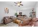 Spacious living room with brown sofas, a coffee table, and a massage chair at 417 Pinecrest Loop, Davenport, FL 33837