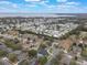 Aerial view of a residential neighborhood near a lake, showcasing various houses and landscaping at 4520 Abaco Dr, Tavares, FL 32778