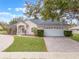 Single-story home with a paved driveway and landscaped lawn at 4520 Abaco Dr, Tavares, FL 32778