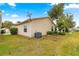 Tan vinyl-sided house exterior with a grassy yard, satellite dish, and AC unit at 453 Hildalgo Dr, Lady Lake, FL 32159