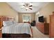 Bright bedroom with a king-size bed and wood dresser at 4557 Antietam Creek Trl, Leesburg, FL 34748