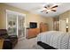 Spacious bedroom with plush carpeting and a ceiling fan at 4557 Antietam Creek Trl, Leesburg, FL 34748