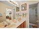 Bathroom featuring dual sinks, a shower, and views into living spaces through doorway at 4822 Sawgrass Lake Cir, Leesburg, FL 34748