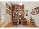 View of the library with floor to ceiling bookshelves, a ladder, hardwood flooring, and a ceiling fan at 4822 Sawgrass Lake Cir, Leesburg, FL 34748