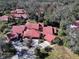 Aerial view of a residential community with red tile roofs and lush landscaping at 601 Waterwood Dr, Yalaha, FL 34797