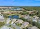 Aerial view of a community with houses near a lake and golf course at 6319 Berkshire Pass, Leesburg, FL 34748