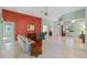 Living room with a red accent wall, and view into other rooms at 6319 Berkshire Pass, Leesburg, FL 34748