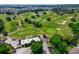 Aerial view of a lush golf course with mature trees and a clubhouse at 810 Maplebrook Loop, Apopka, FL 32703