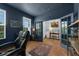 Dark-blue home office with hardwood floors, built-in shelves, and large windows at 810 Maplebrook Loop, Apopka, FL 32703