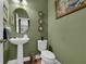 Modern powder room with pedestal sink and green walls at 810 Maplebrook Loop, Apopka, FL 32703