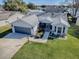 Aerial view of a single-Gathering home with a two-car garage and well-maintained lawn at 830 Cortez Ave, The Villages, FL 32159