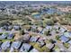 An aerial view of a house situated in a residential neighborhood near a lake at 830 Cortez Ave, The Villages, FL 32159