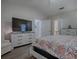 Bright bedroom with a dresser, large TV and en-suite bathroom access at 830 Cortez Ave, The Villages, FL 32159
