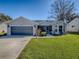 White single-story house with a two-car garage and landscaped front yard at 830 Cortez Ave, The Villages, FL 32159