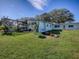 Landscaped backyard with a screened pool and patio area at 908 N Lakeshore Blvd, Howey In The Hills, FL 34737