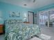 Peaceful bedroom with tropical bedding, water view, and private access to balcony at 908 N Lakeshore Blvd, Howey In The Hills, FL 34737