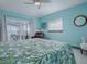 Serene bedroom with leafy bedding and relaxing water views from sliders to screened porch at 908 N Lakeshore Blvd, Howey In The Hills, FL 34737