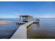 Private boat dock with covered boathouse on a calm lake at 908 N Lakeshore Blvd, Howey In The Hills, FL 34737